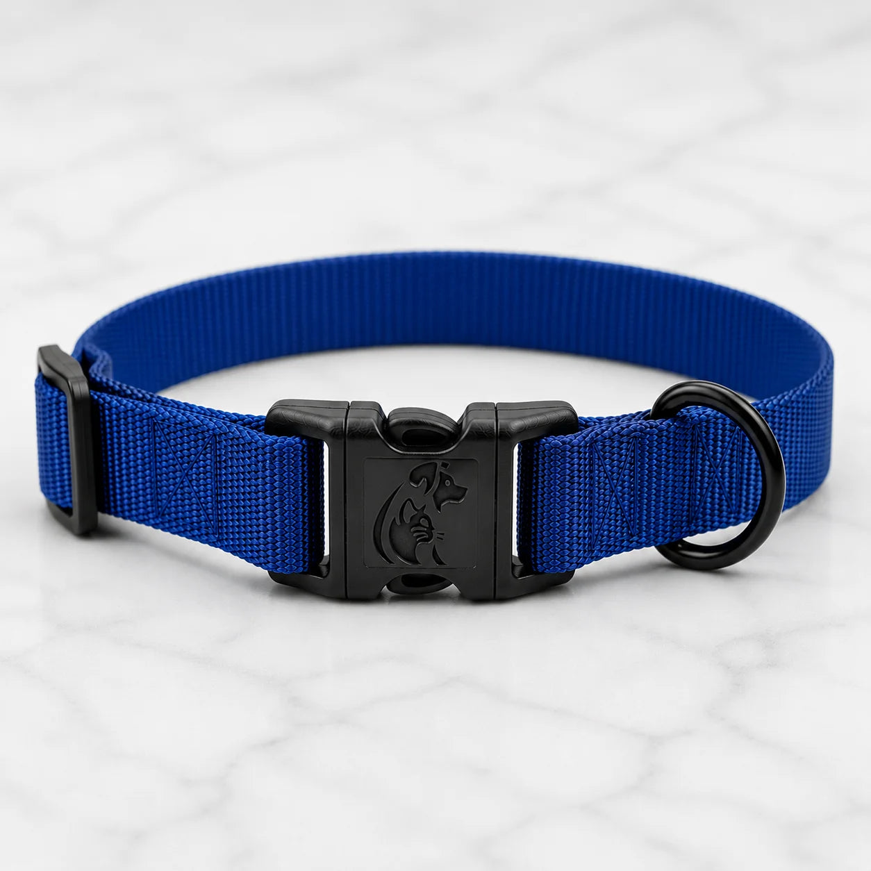 Blue nylon dog collar with black plastic buckle and ring on white marble surface