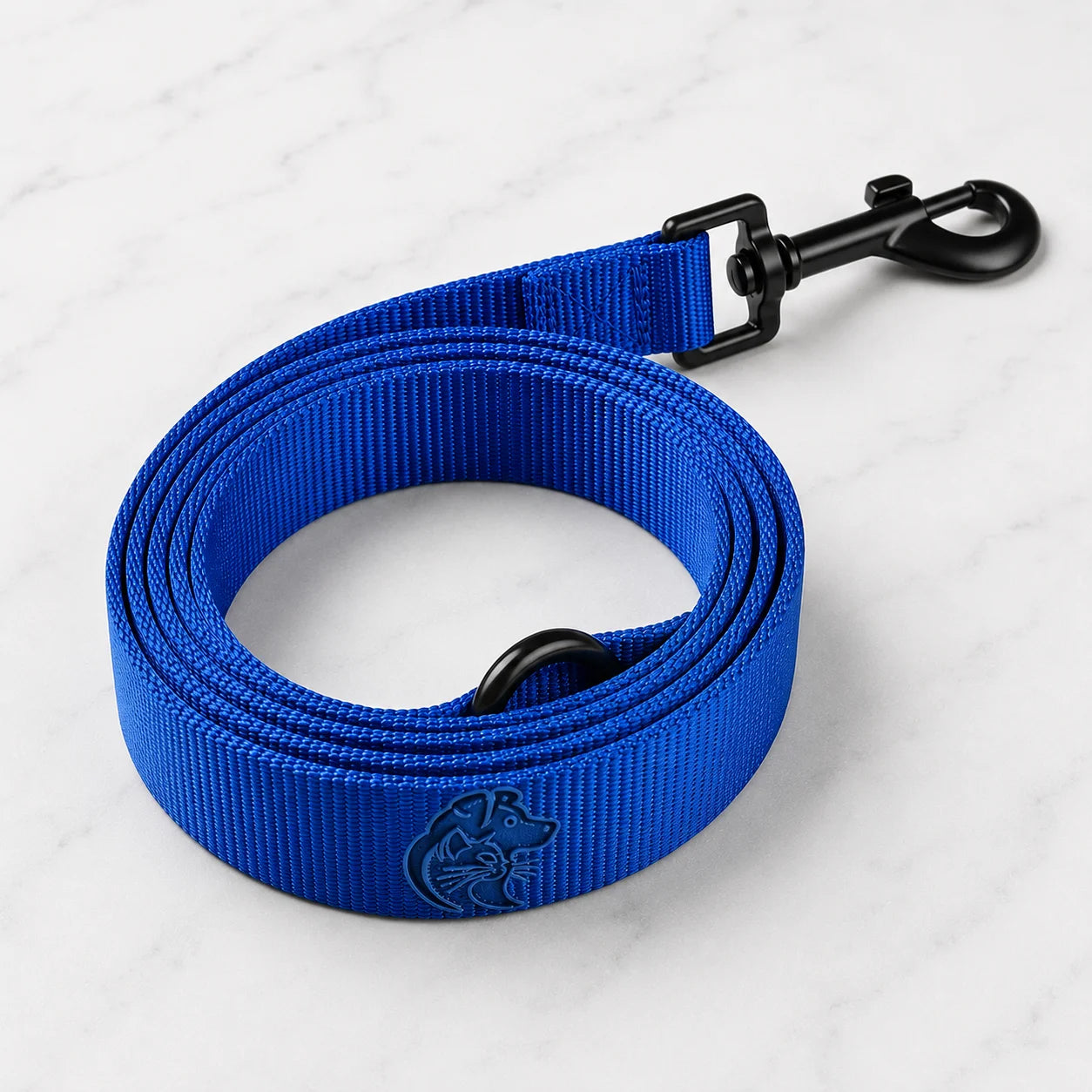 A royal blue dog leash with a black clasp on a white marble surface