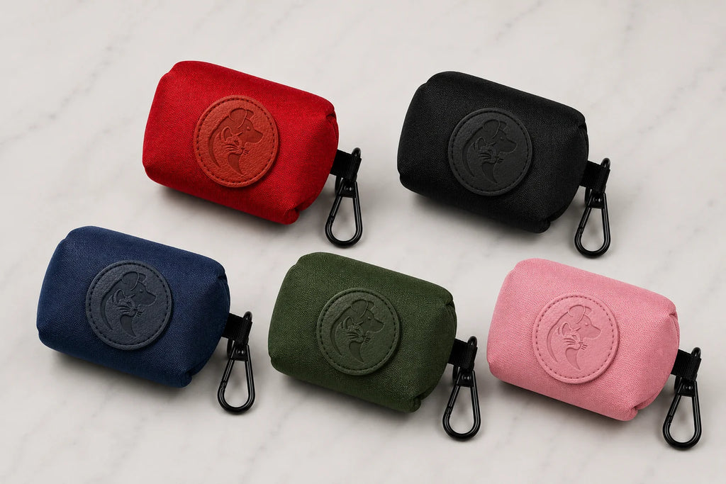 Five colorful poop bag holders with black clips and logo on a white marble surface