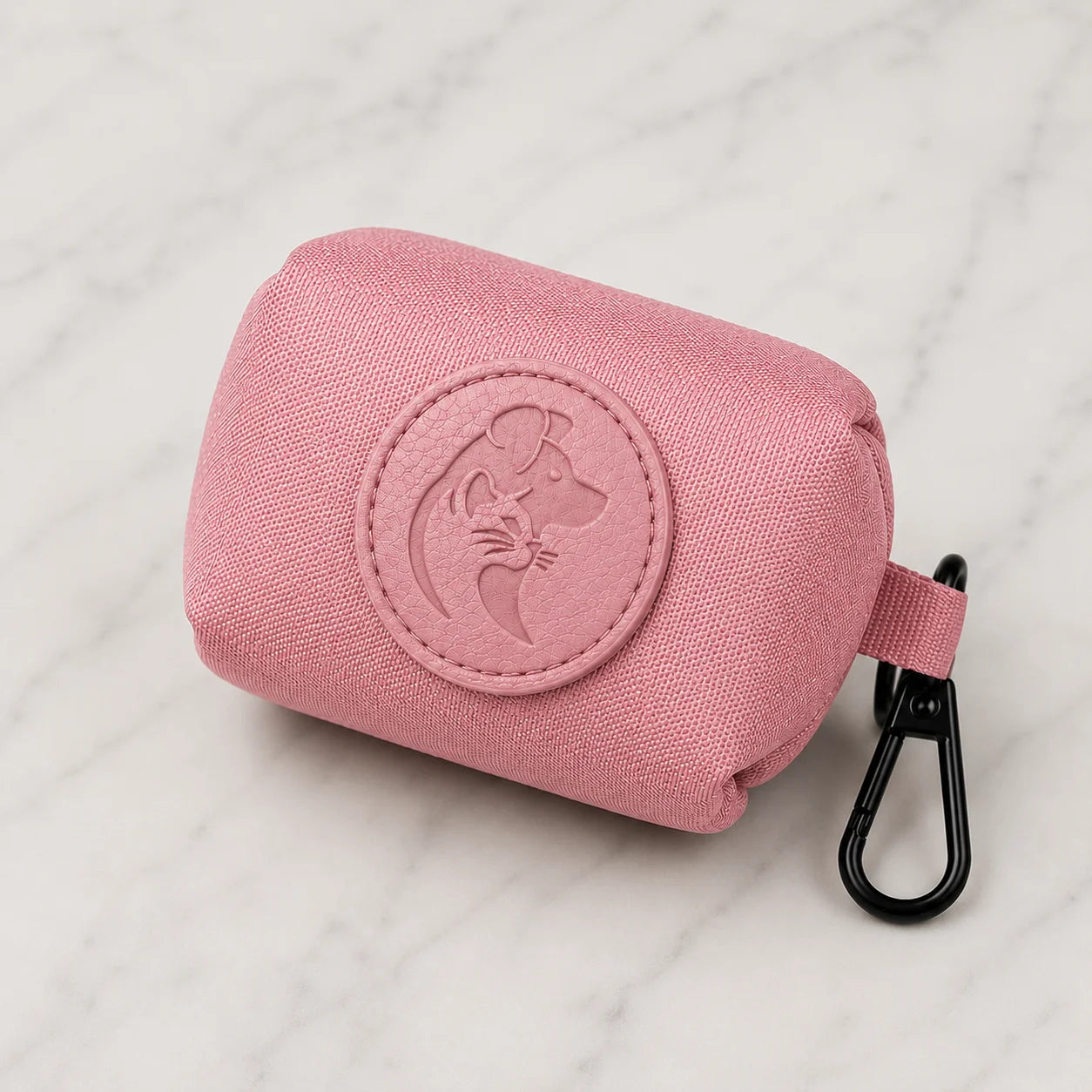 Pink fabric pouch with embossed dog and baby design on marble background with black clip